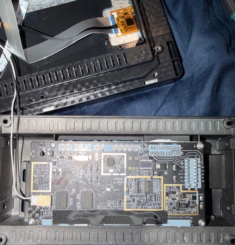 Shaddow hardware mid-disassembly laid out on dark velvet — exposed PCB, ribbon harnesses, and machined enclosure halves arranged like an exploded view.
